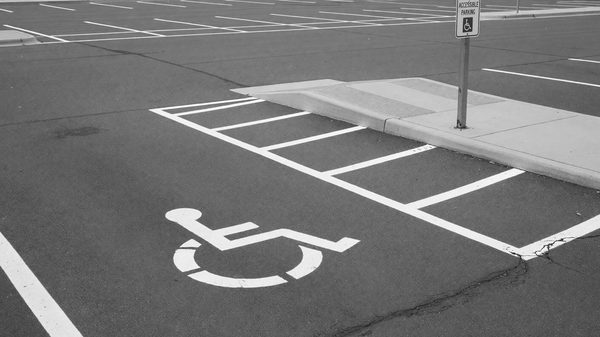 A parking gate kiosk designed with accessible reach heights and clear pavement around the operable controls