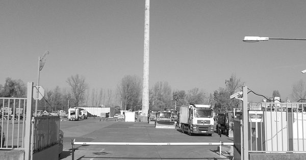 Automatic boom barrier gate guarding an industrial site entry
