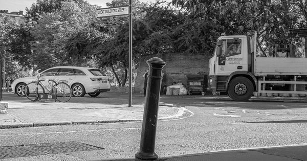 Heavy steel crash-rated bollard at a street corner