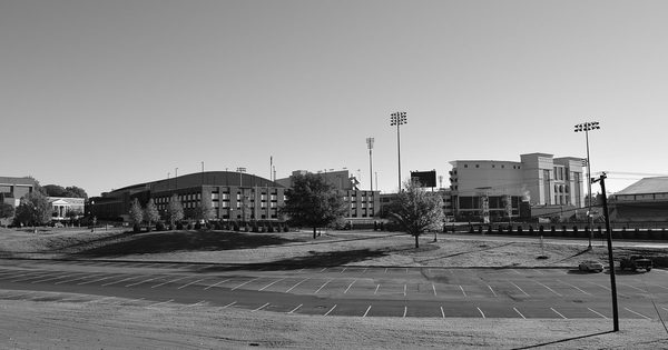University campus commuter parking lot with buildings beyond