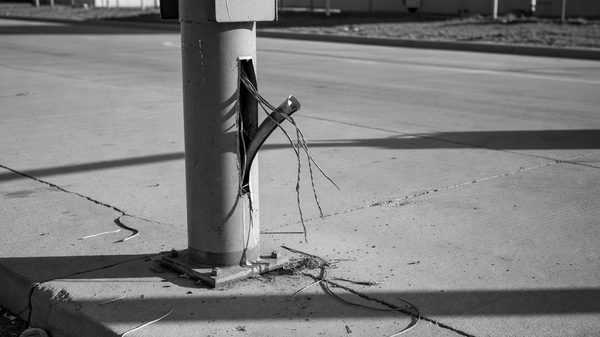 Exposed conduit at a barrier gate site showing where thieves have pulled cable from the pedestal