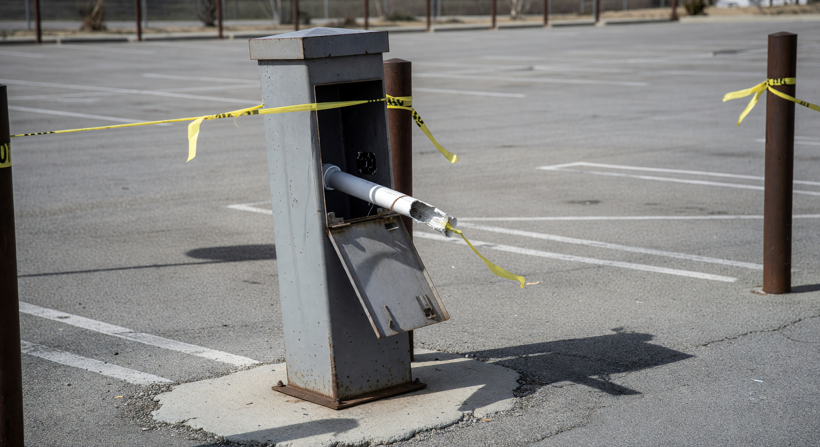 Exposed conduit at a barrier gate site showing where thieves have pulled cable from the pedestal
