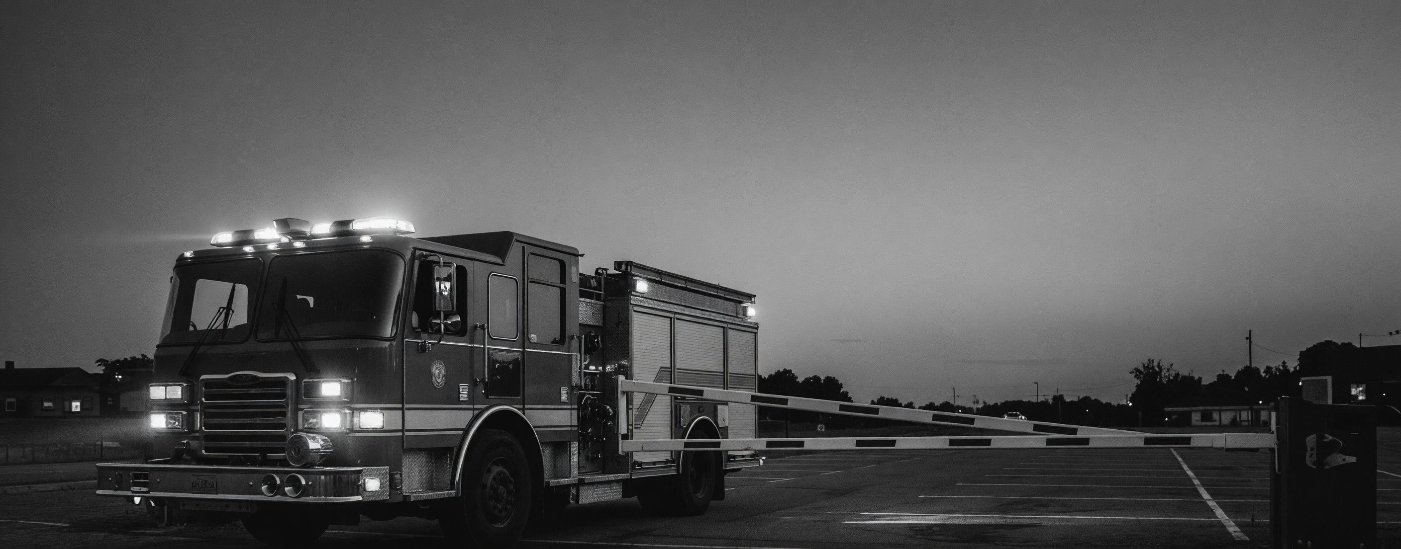 Fire apparatus approaching a parking barrier gate that is rising automatically in response to an emergency preemption signal