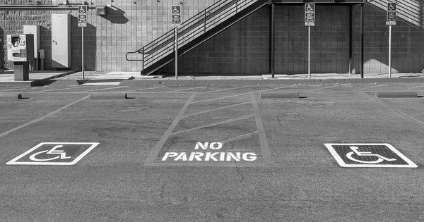 Striped parking lot pavement with marked vehicle spaces