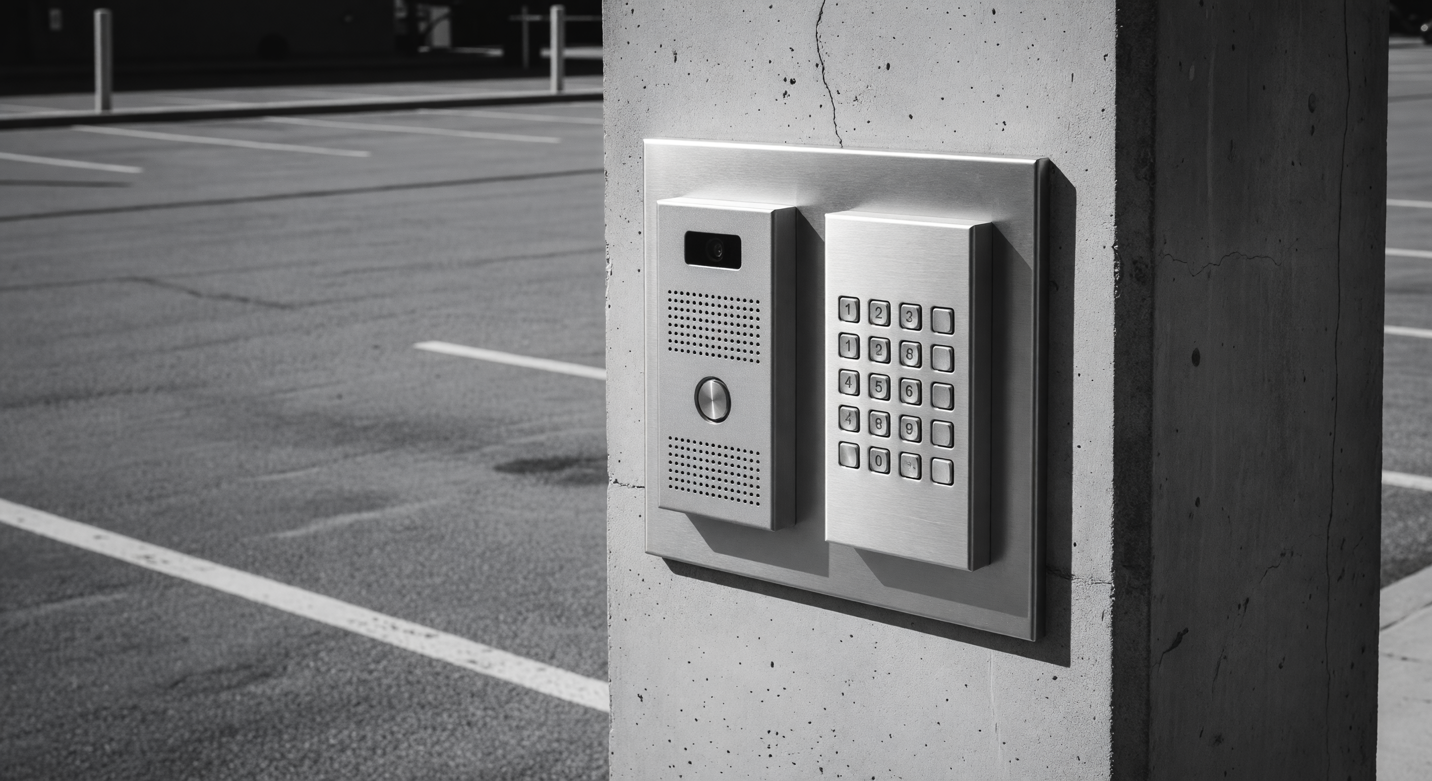 A video intercom station integrated into a parking barrier gate pedestal at an unattended commercial entrance