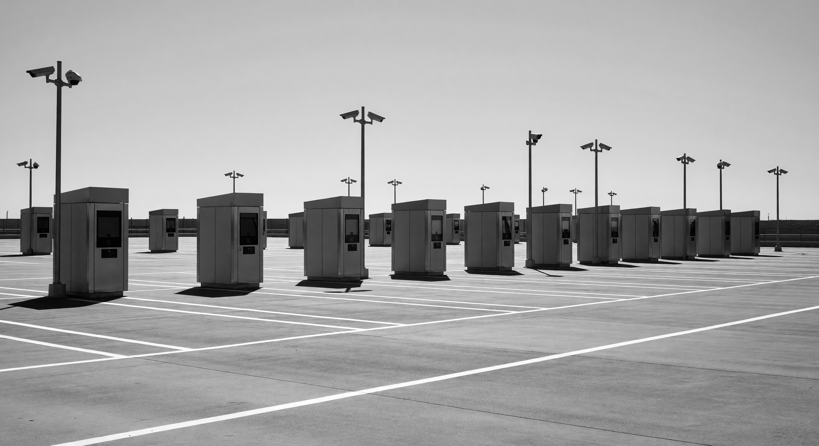 Three parking barrier gates arranged side-by-side in a high-volume commercial entrance plaza