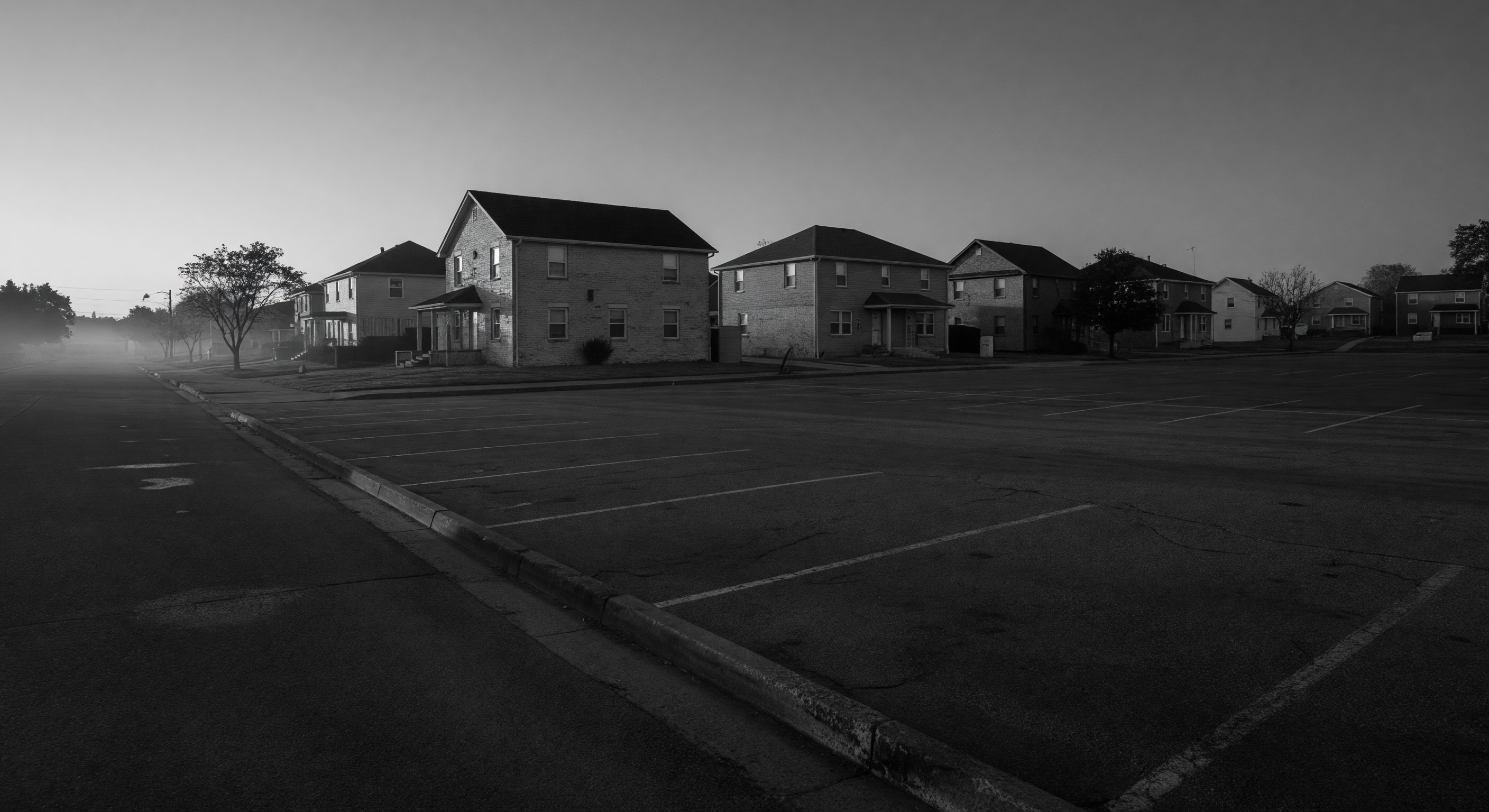 Parking barrier gate installation at multifamily residential entrance with sound baffle