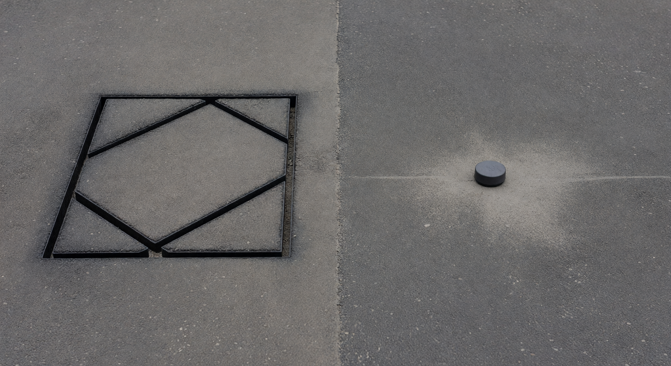 Pavement view comparing a sawcut inductive loop next to a surface-mounted wireless magnetometer puck